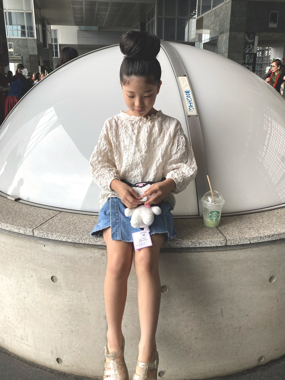 ブルー系のデニムスカート、ホワイト系のサンダルを着用したレディースの秋コーディネートの3枚目の写真