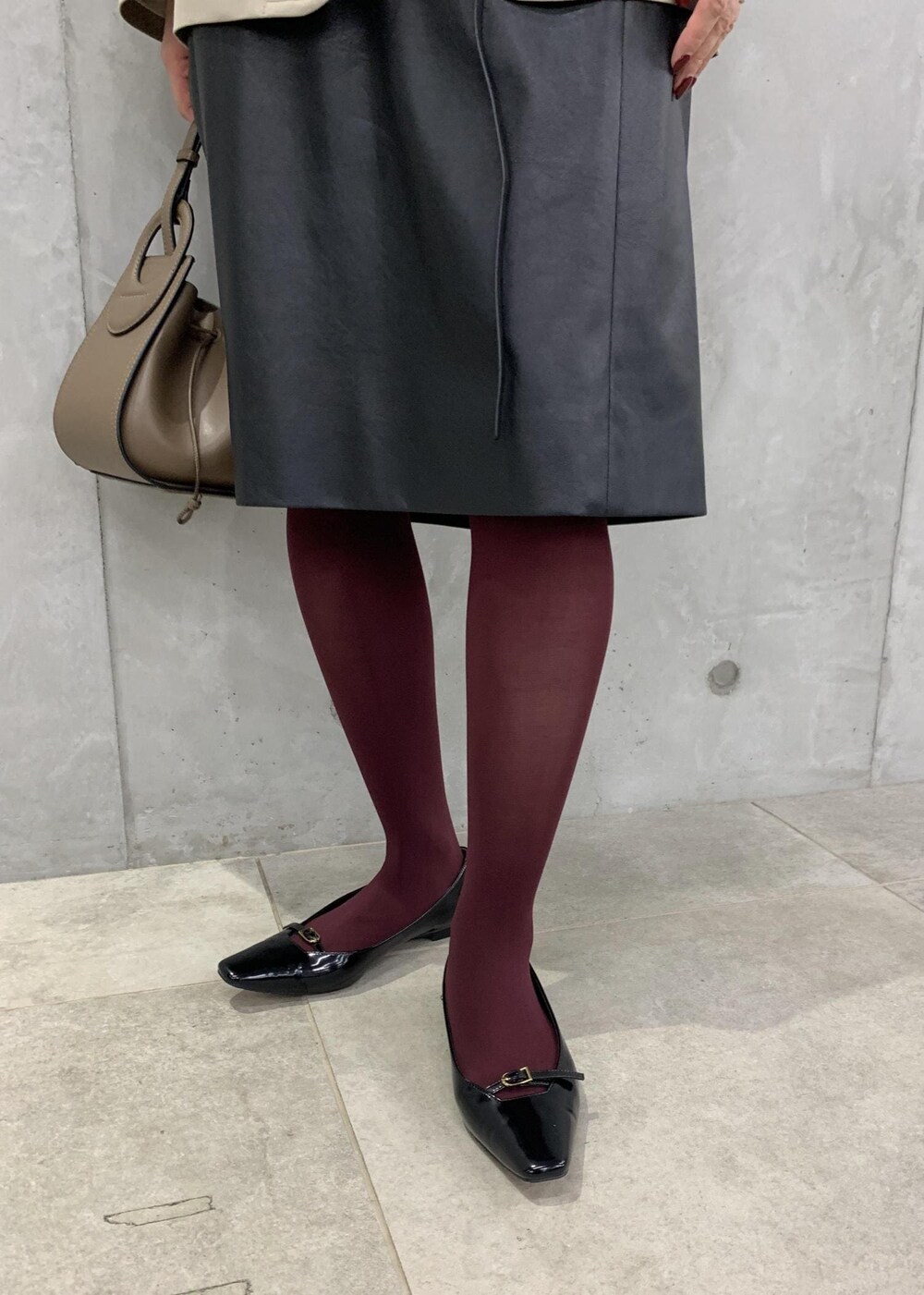 ベージュ系のテーラードジャケット、ブラック系のパンプス、ベージュ系のハンドバッグを着用したレディースの秋コーディネートの6枚目の写真