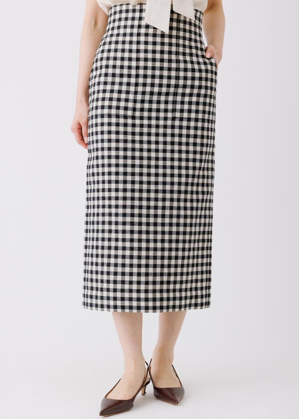 ブラック系のスカート、ベージュ系のシャツ/ブラウス、グレー系のトートバッグを着用したレディースの春コーディネートの6枚目の写真