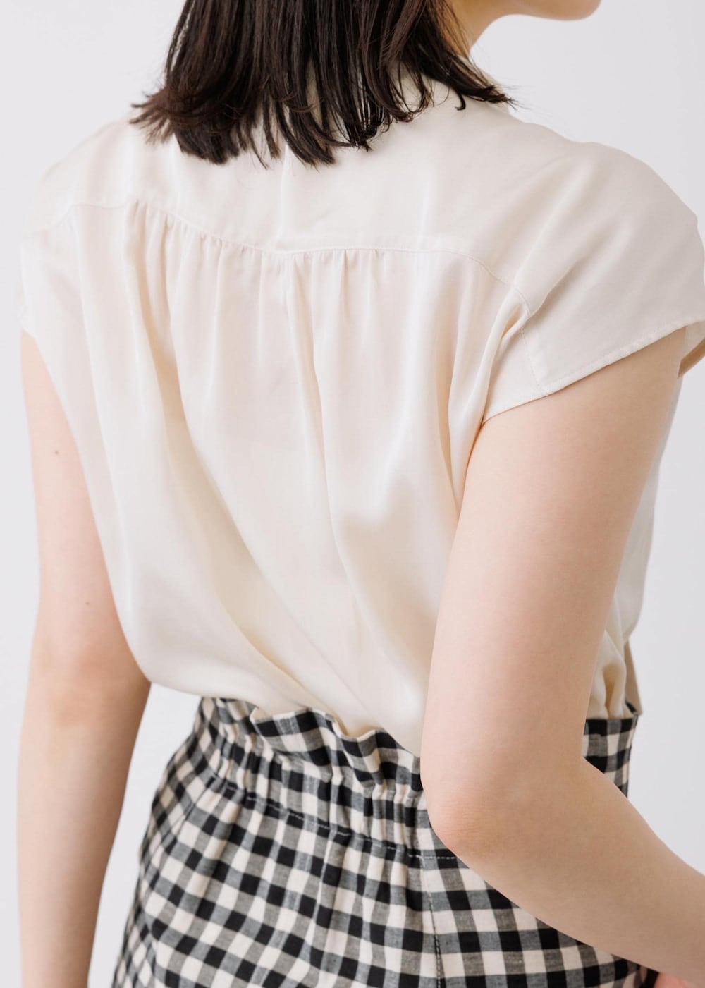 ブラック系のスカート、ベージュ系のシャツ/ブラウス、グレー系のトートバッグを着用したレディースの春コーディネートの5枚目の写真