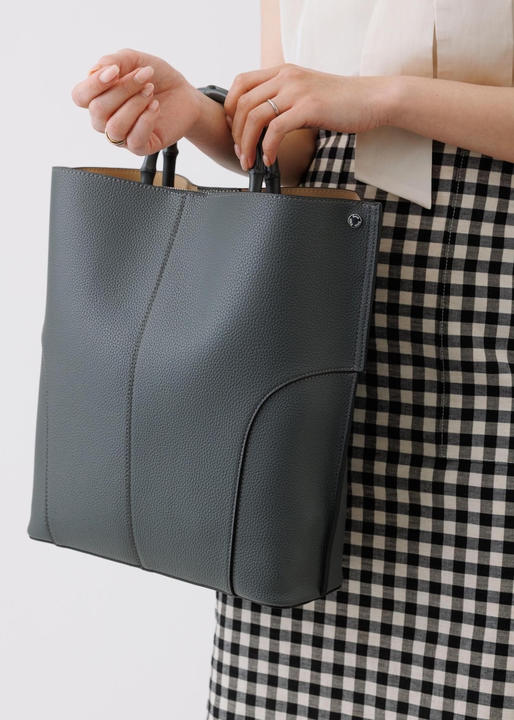 ブラック系のスカート、ベージュ系のシャツ/ブラウス、グレー系のトートバッグを着用したレディースの春コーディネートの10枚目の写真