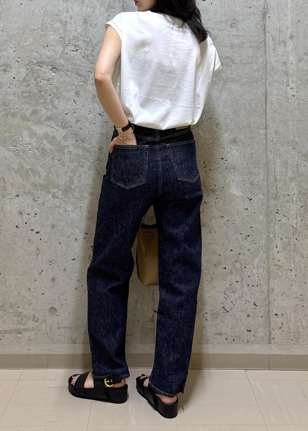 ブラック系のサンダル、ホワイト系のTシャツ/カットソー、ブルー系のデニムパンツを着用したレディースの夏コーディネートの4枚目の写真