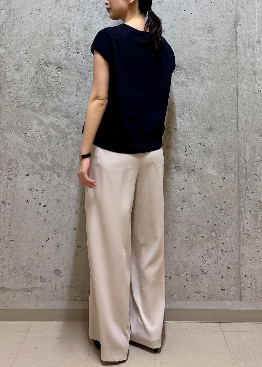 グレー系のトートバッグ、ブラック系のパンプス、ブルー系のニット/セーターを着用したレディースの春コーディネートの8枚目の写真