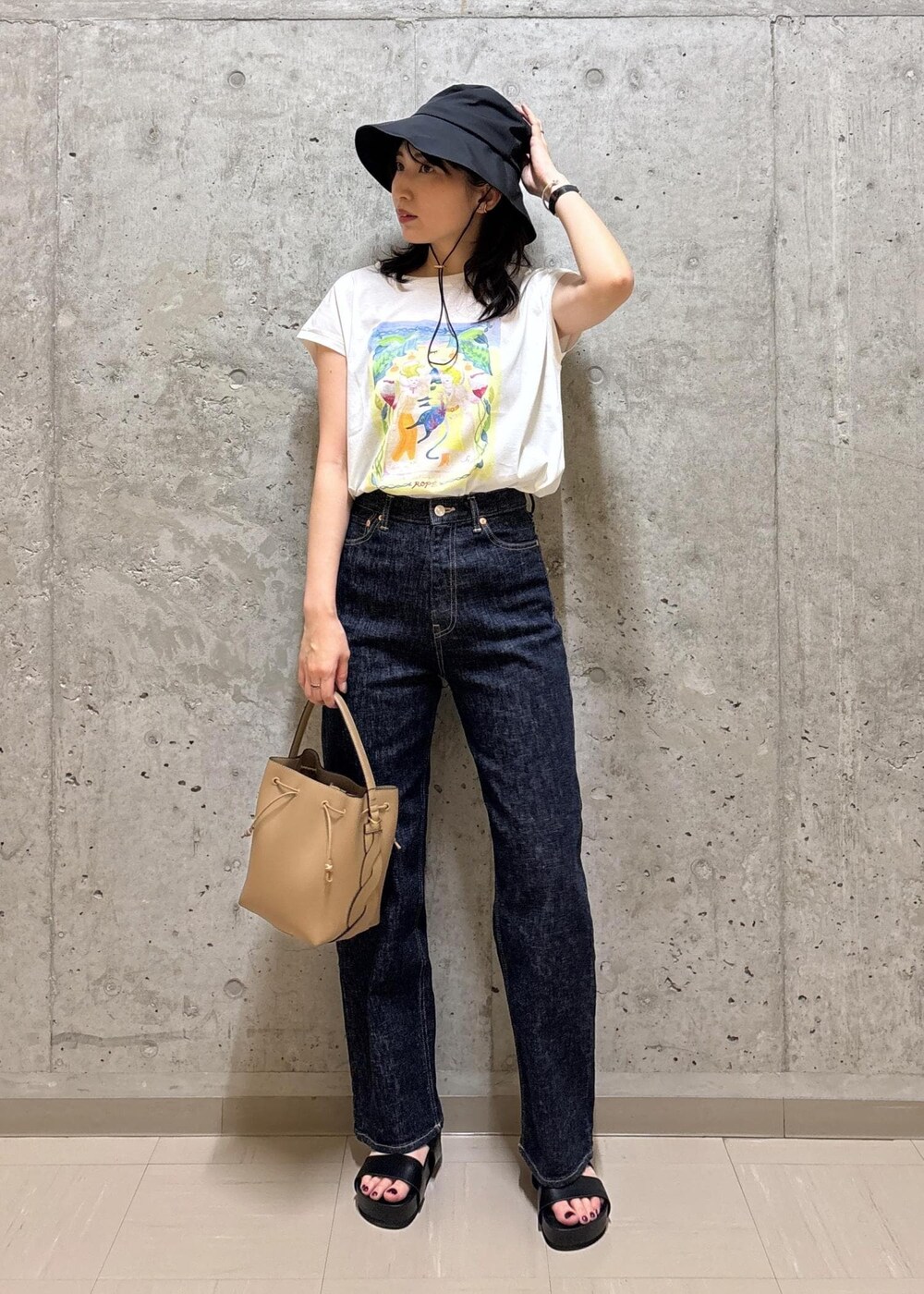 ブラック系のサンダル、ホワイト系のTシャツ/カットソー、ブルー系のデニムパンツを着用したレディースの夏コーディネートの2枚目の写真