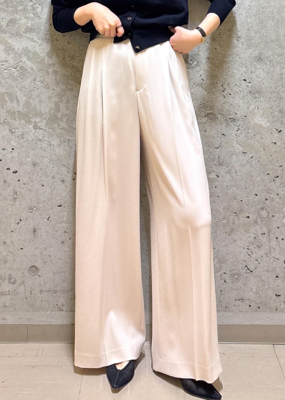 グレー系のトートバッグ、ブラック系のパンプス、ブルー系のニット/セーターを着用したレディースの春コーディネートの9枚目の写真