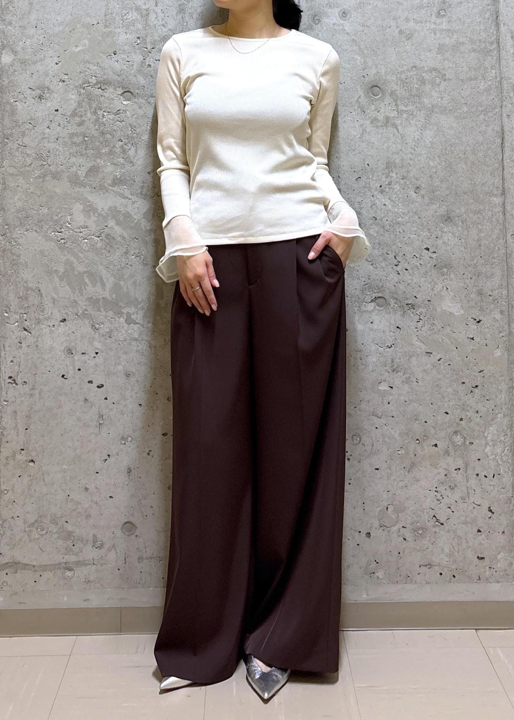 シルバー系のパンプス、ホワイト系のハンドバッグ、ブラウン系のテーラードジャケットを着用したレディースの春コーディネートの7枚目の写真