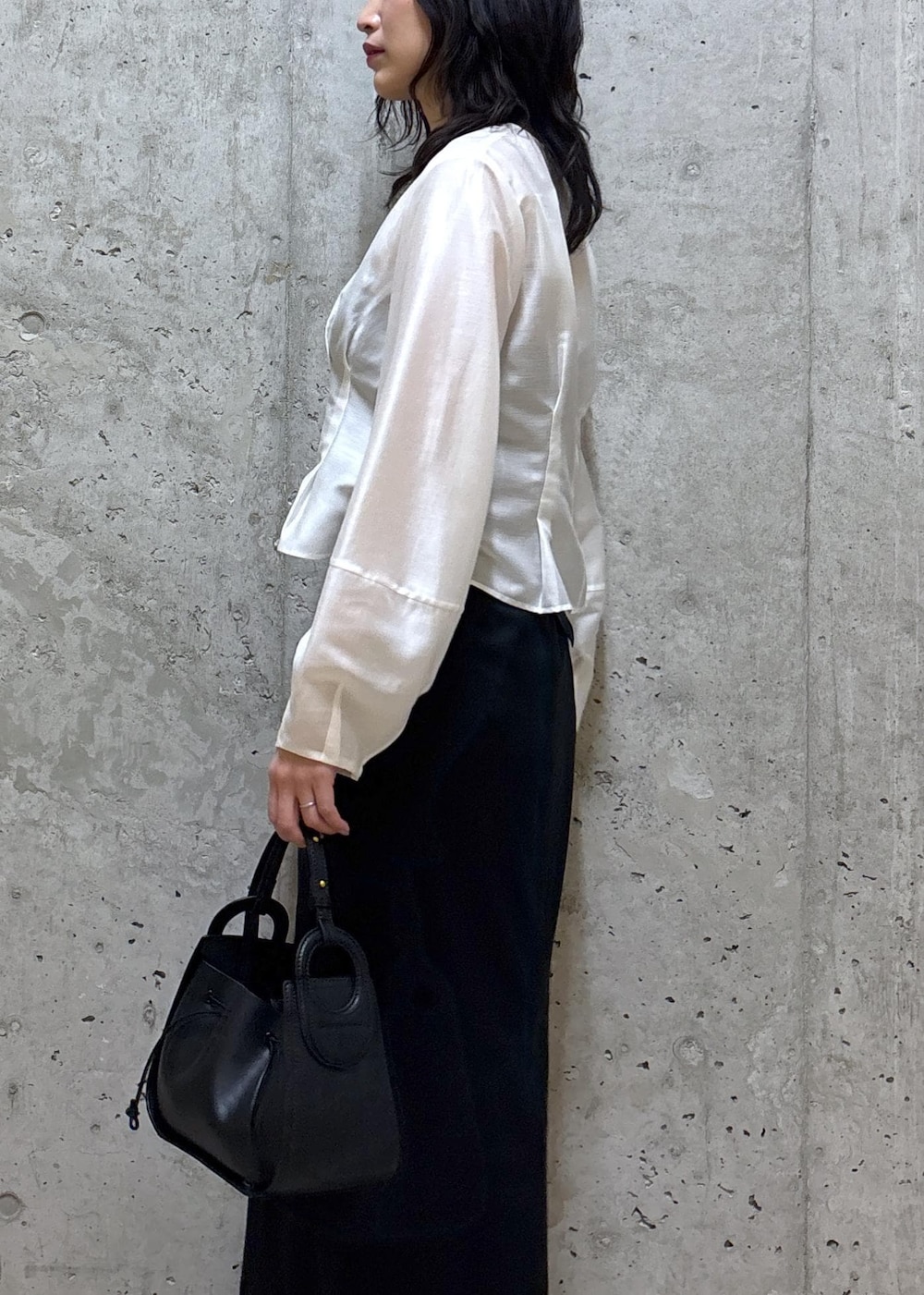 ブラック系のハンドバッグ、ブラック系のブーツ、ブラック系のスカートを着用したレディースの春コーディネートの5枚目の写真