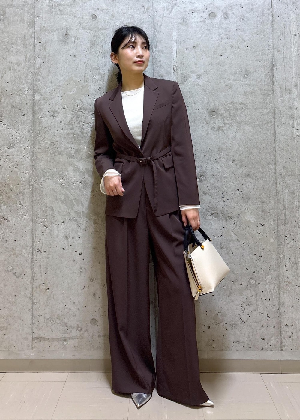 シルバー系のパンプス、ホワイト系のハンドバッグ、ブラウン系のテーラードジャケットを着用したレディースの春コーディネートの8枚目の写真