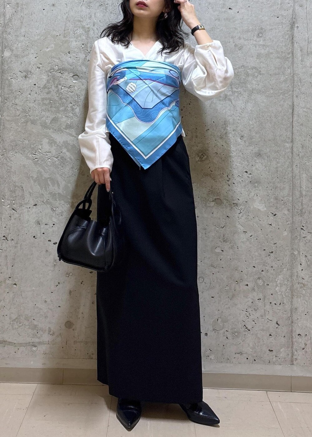 ブラック系のハンドバッグ、ブラック系のブーツ、ブラック系のスカートを着用したレディースの春コーディネートの2枚目の写真