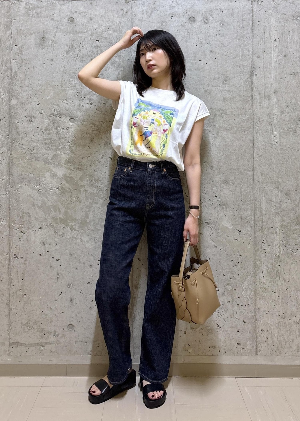 ブラック系のサンダル、ホワイト系のTシャツ/カットソー、ブルー系のデニムパンツを着用したレディースの夏コーディネートの5枚目の写真