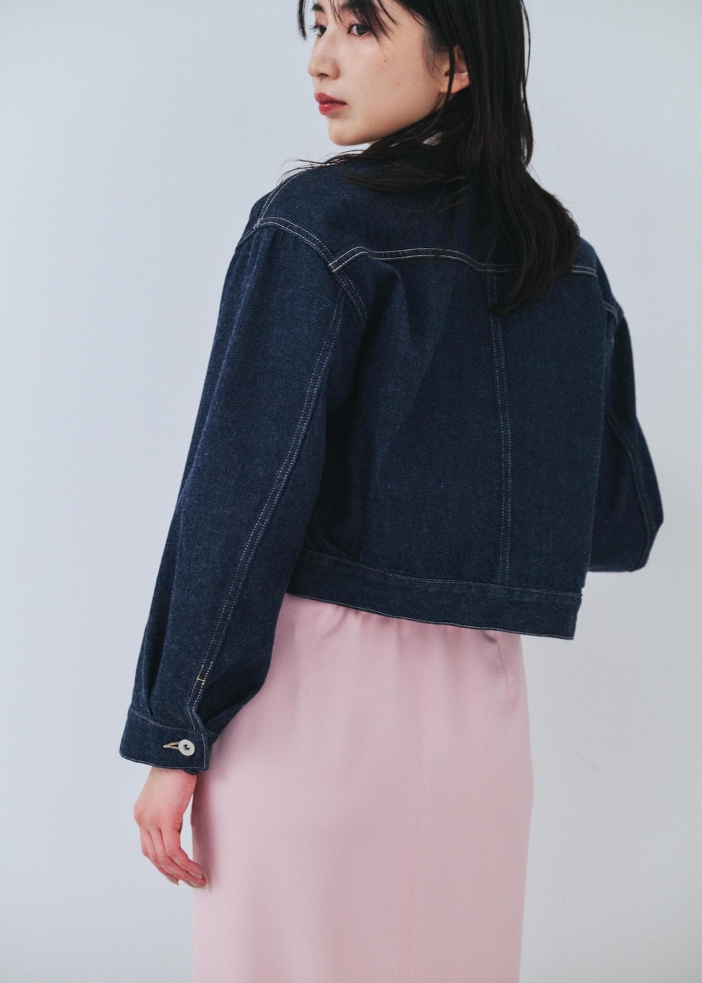 ピンク系のスカート、ブルー系のデニムジャケットを着用したレディースの冬コーディネートの5枚目の写真