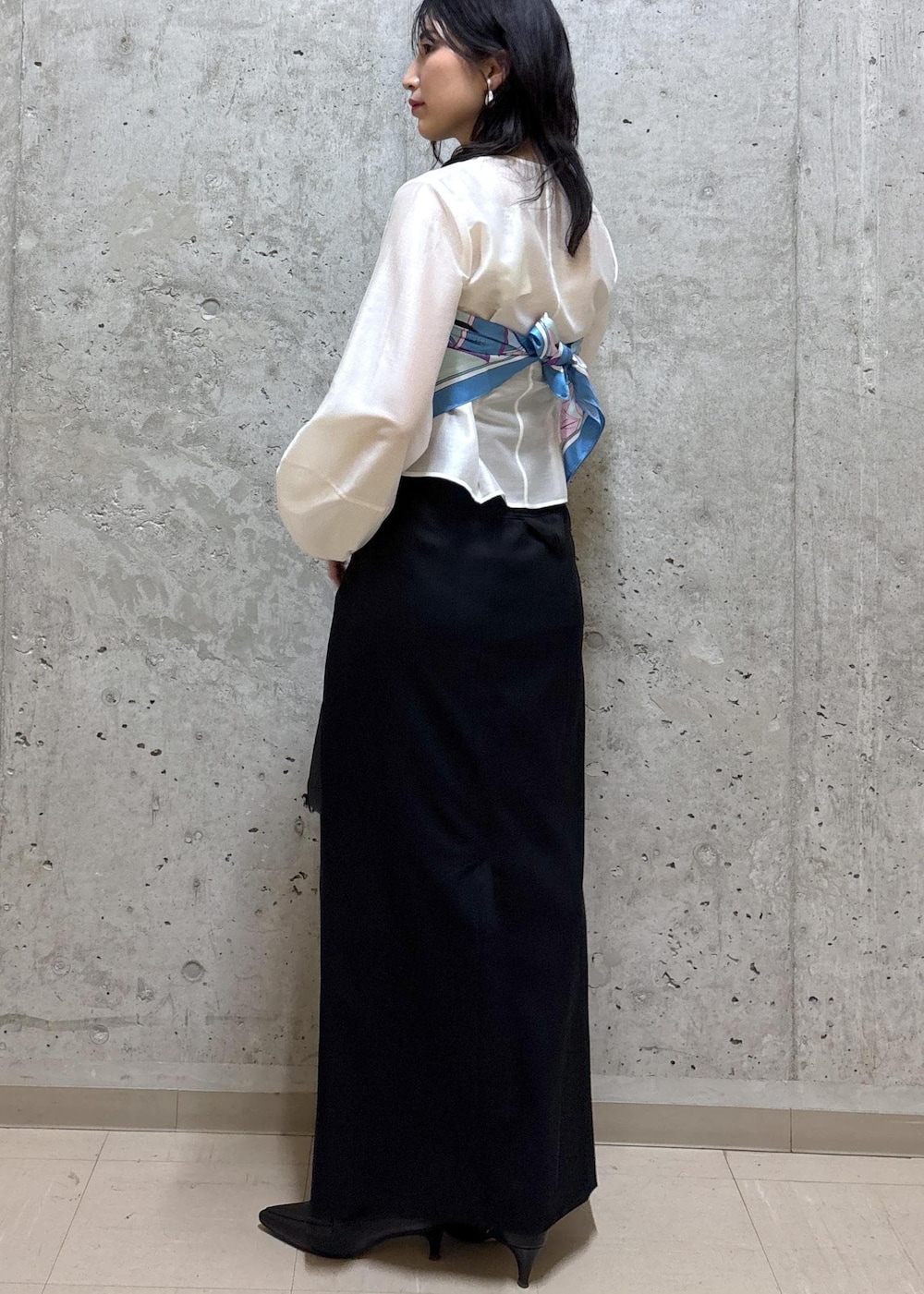 ブラック系のハンドバッグ、ブラック系のブーツ、ブラック系のスカートを着用したレディースの春コーディネートの3枚目の写真