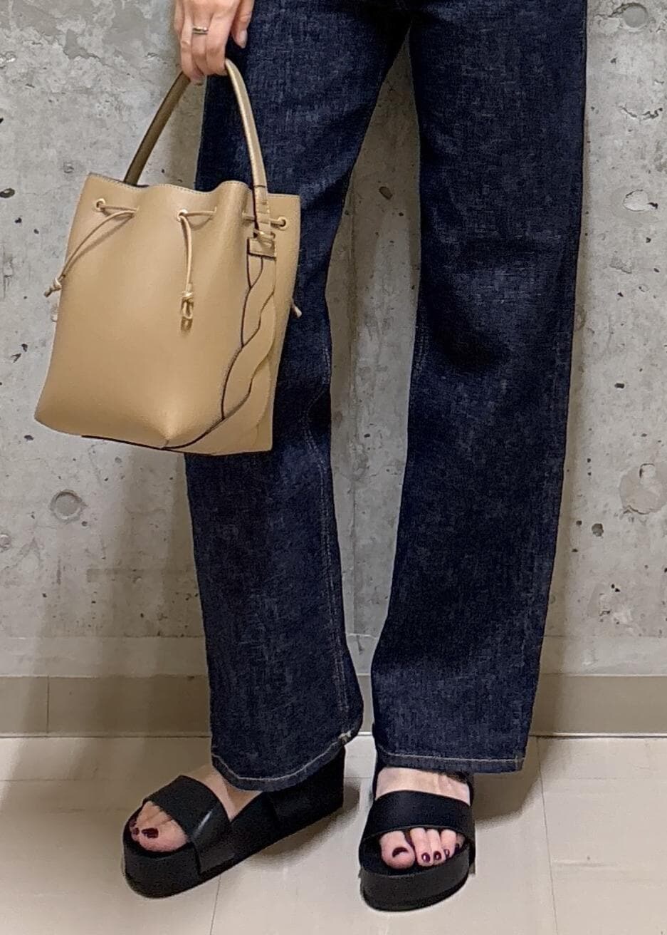 ブラック系のサンダル、ホワイト系のTシャツ/カットソー、ブルー系のデニムパンツを着用したレディースの夏コーディネートの9枚目の写真