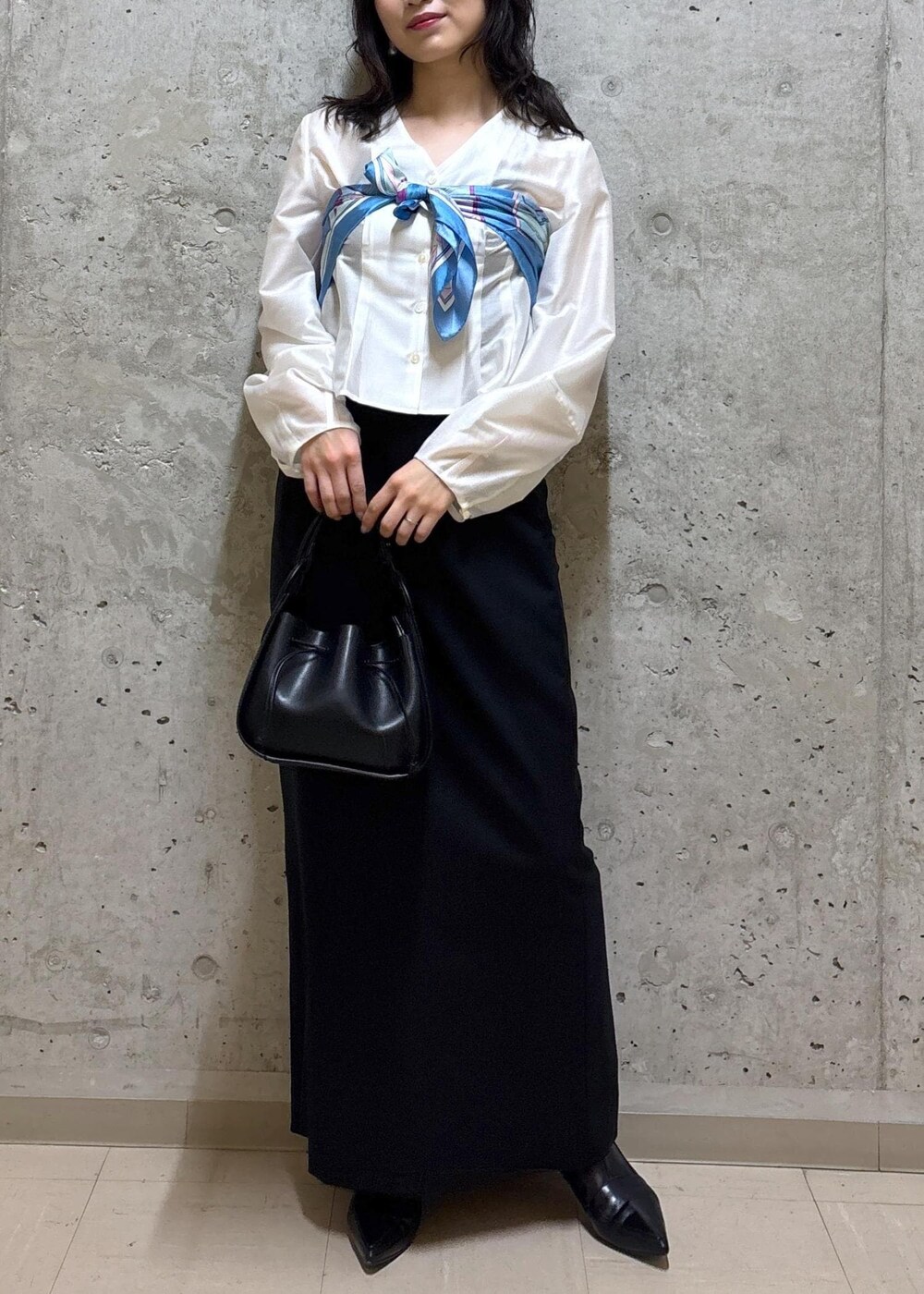 ブラック系のハンドバッグ、ブラック系のブーツ、ブラック系のスカートを着用したレディースの春コーディネートの8枚目の写真