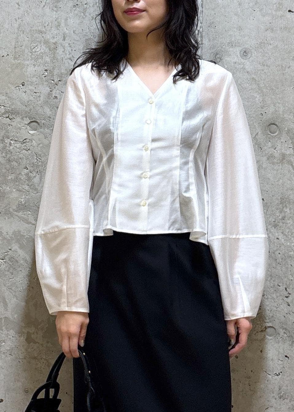 ブラック系のハンドバッグ、ブラック系のブーツ、ブラック系のスカートを着用したレディースの春コーディネートの4枚目の写真