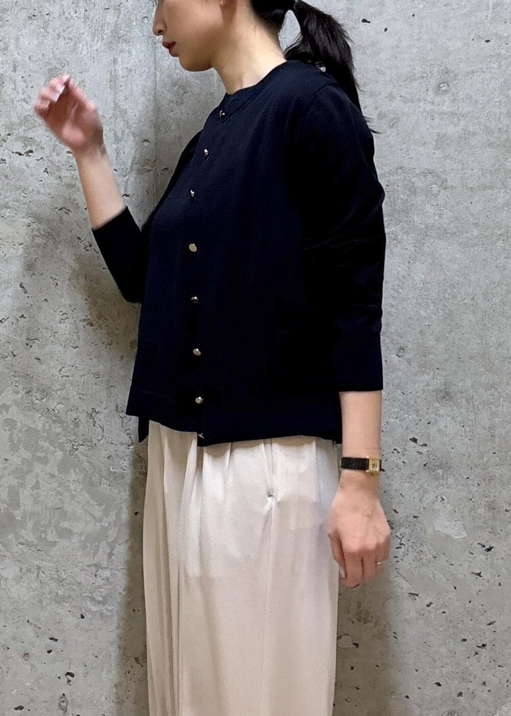 グレー系のトートバッグ、ブラック系のパンプス、ブルー系のニット/セーターを着用したレディースの春コーディネートの5枚目の写真