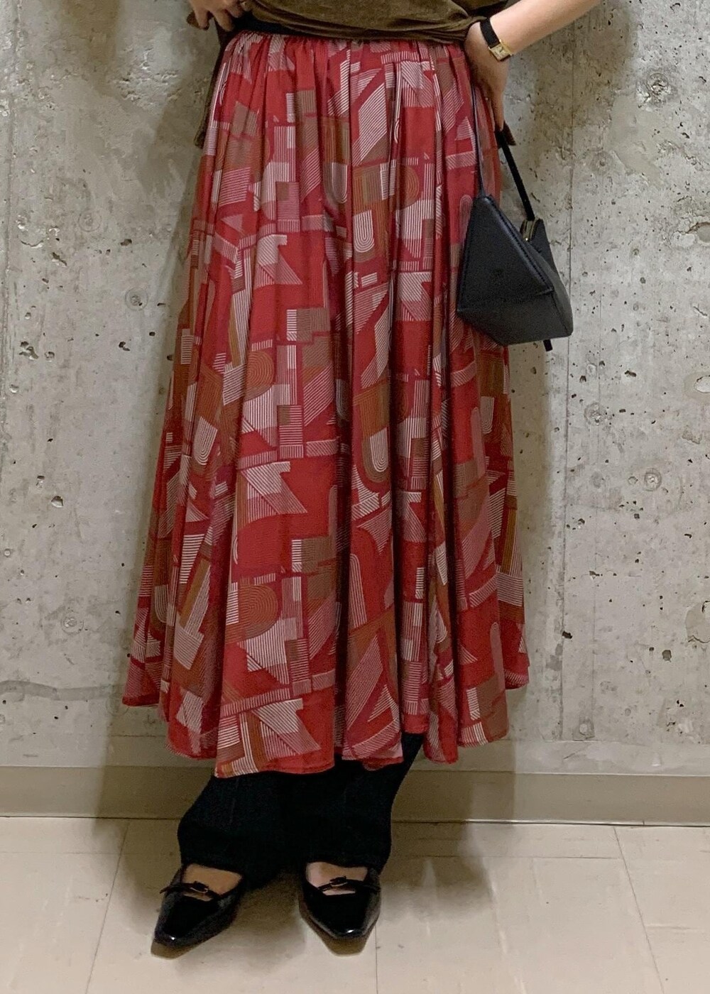 ブルー系のデニムパンツ、ブラウン系のTシャツ/カットソー、レッド系のスカートを着用したレディースの夏コーディネートの6枚目の写真