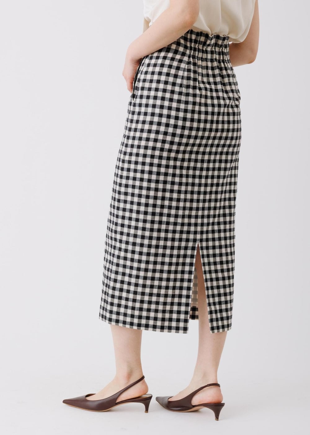 ブラック系のスカート、ベージュ系のシャツ/ブラウス、グレー系のトートバッグを着用したレディースの春コーディネートの8枚目の写真