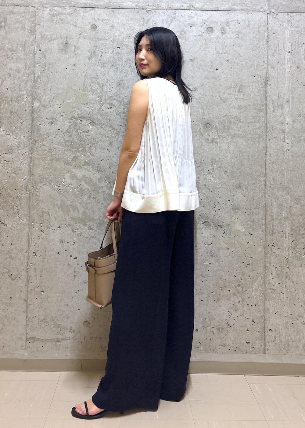 ホワイト系のシャツ/ブラウス、ブルー系のその他パンツ、ベージュ系のハンドバッグを着用したレディースの夏コーディネートの3枚目の写真