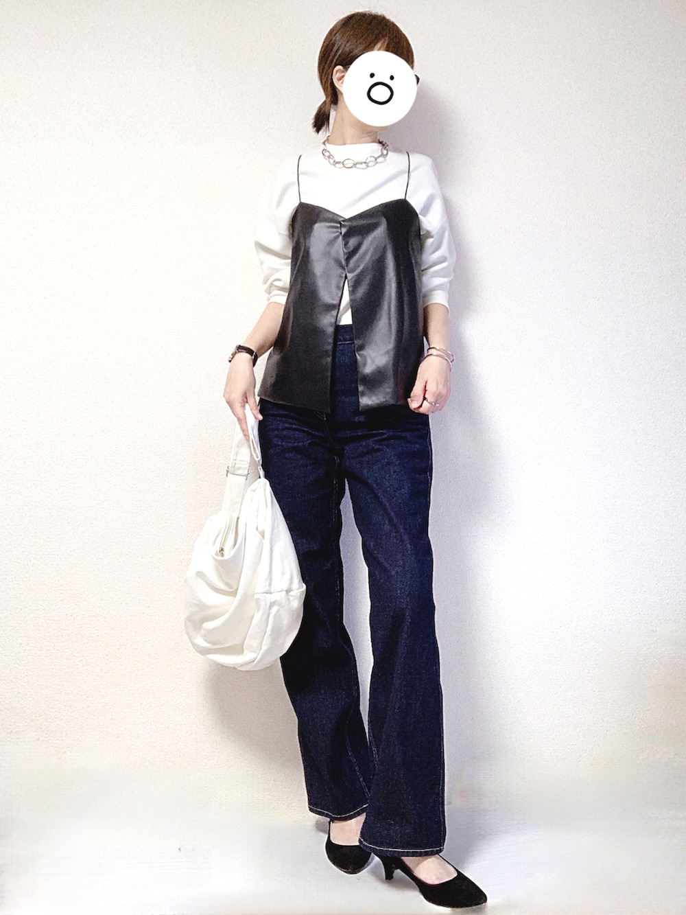 ホワイト系のショルダーバッグ、ブルー系のデニムパンツ、ブラック系のパンプスを着用したレディースの秋コーディネートの2枚目の写真