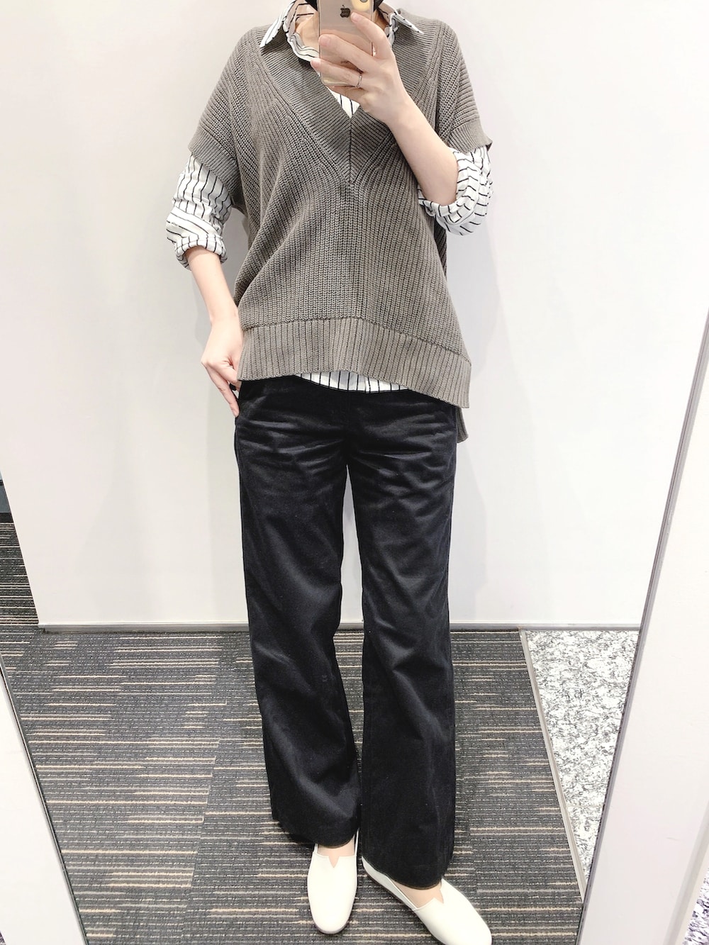 グレー系のベスト、ブラック系のチノパンツ、ブラック系のバックパック/リュックを着用したレディースの春コーディネートの2枚目の写真