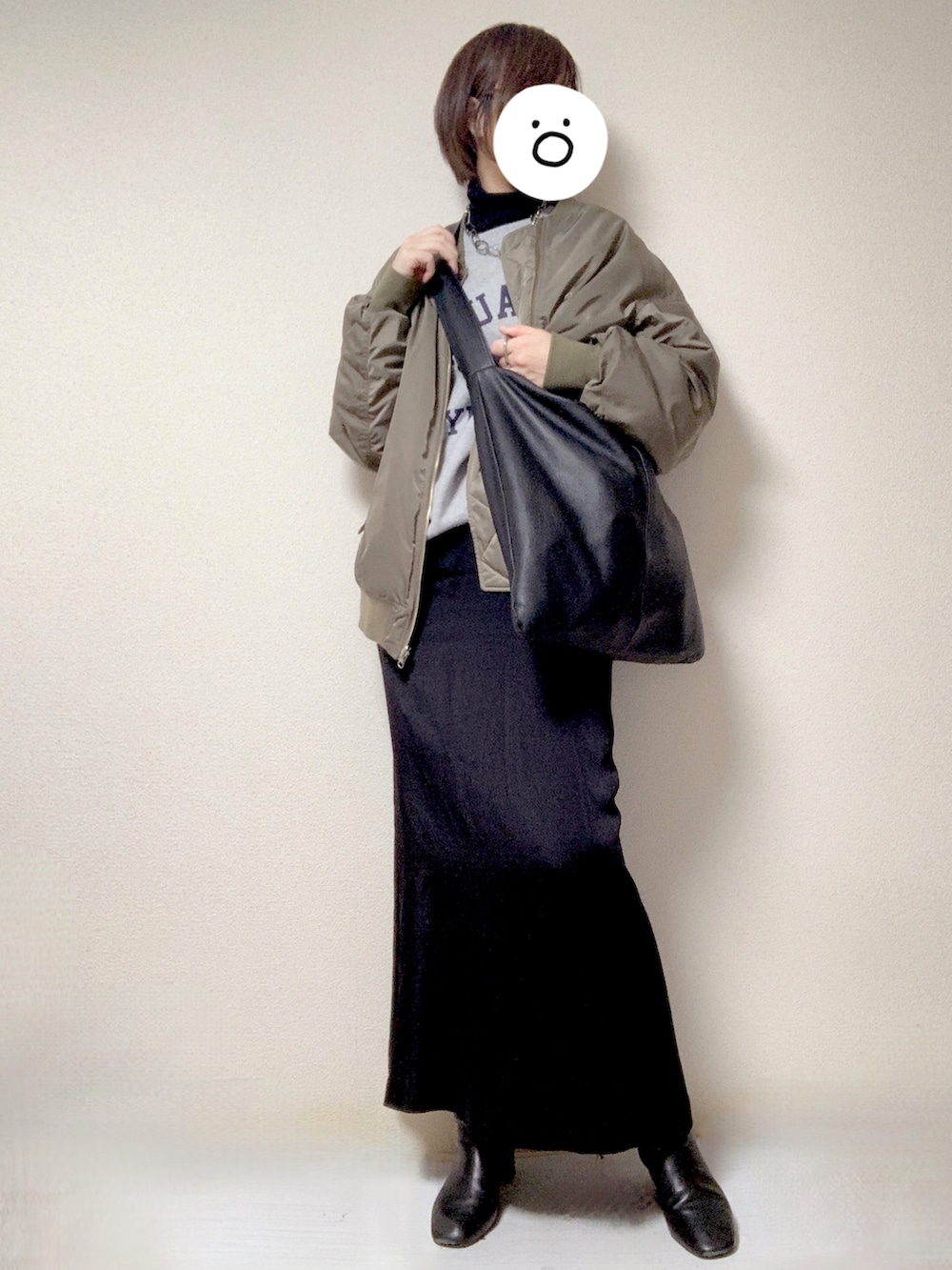 ブラック系のブーツ、ブラック系のスカート、グレー系のMA-1を着用したレディースの冬コーディネートの2枚目の写真