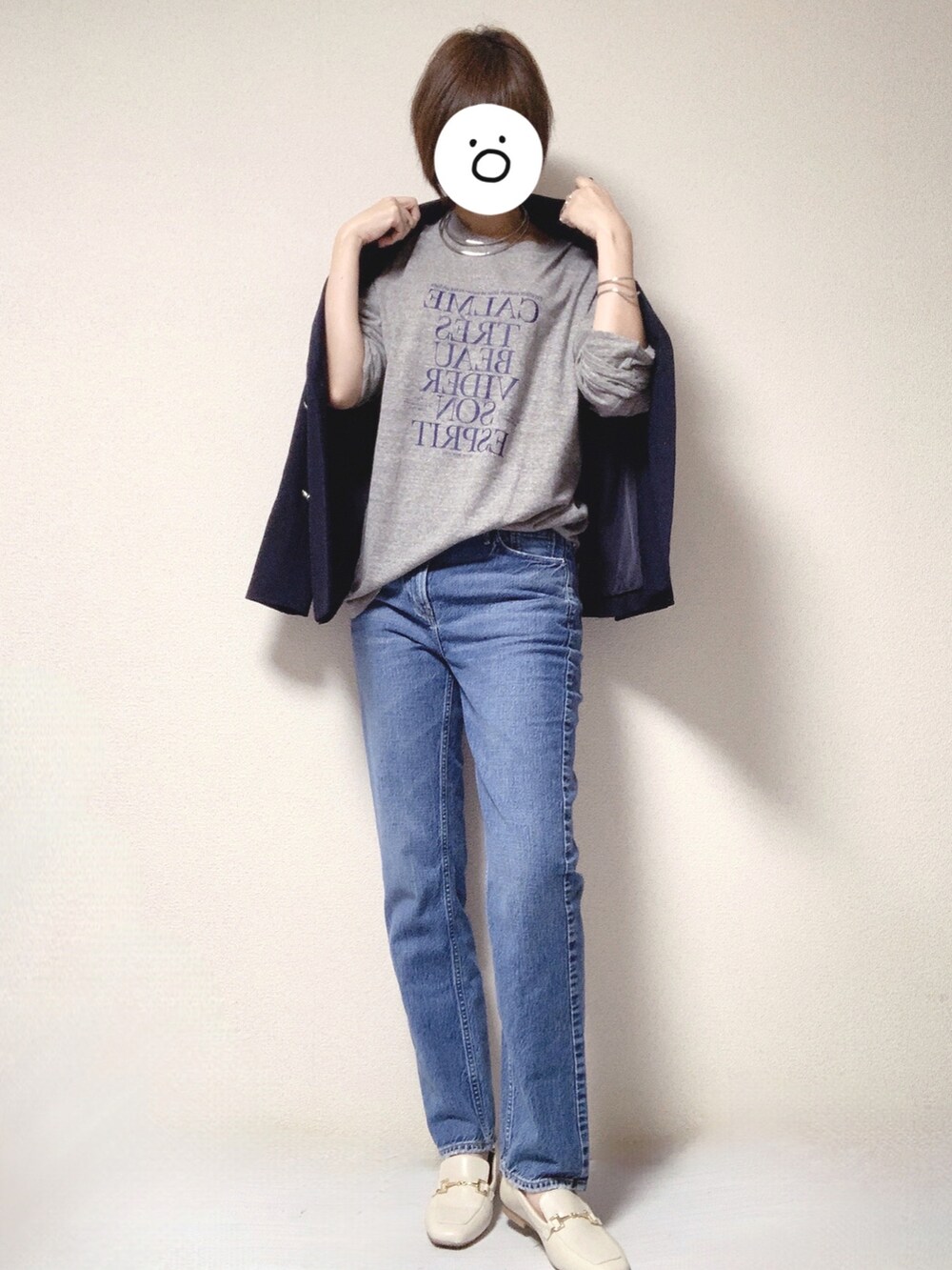 ブルー系のデニムパンツ、ベージュ系のトートバッグ、グレー系のTシャツ/カットソーを着用したレディースの秋コーディネートの2枚目の写真