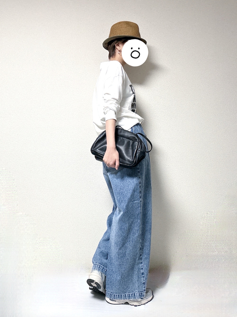 ホワイト系のTシャツ/カットソー、ブルー系のデニムパンツ、ブラック系のトートバッグを着用したレディースの春コーディネートの2枚目の写真