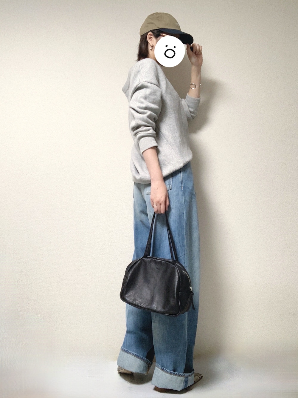 ベージュ系のパンプス、ブラック系のトートバッグ、ブルー系のデニムパンツを着用したレディースの春コーディネートの2枚目の写真