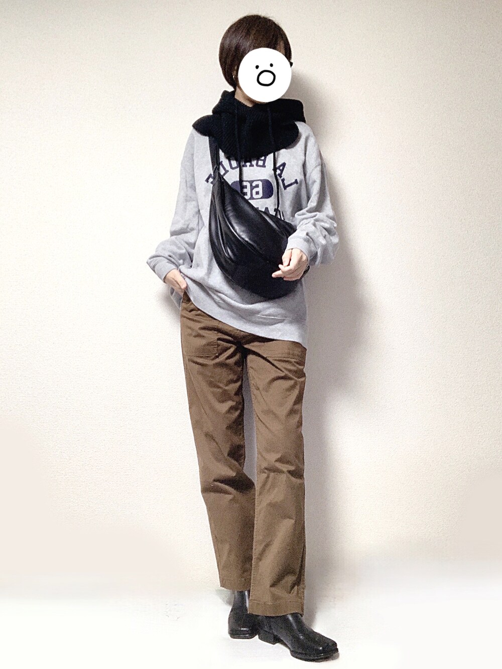 グレー系のスウェット、ブラック系のショルダーバッグ、ブラウン系のチノパンツを着用したレディースの秋コーディネートの3枚目の写真