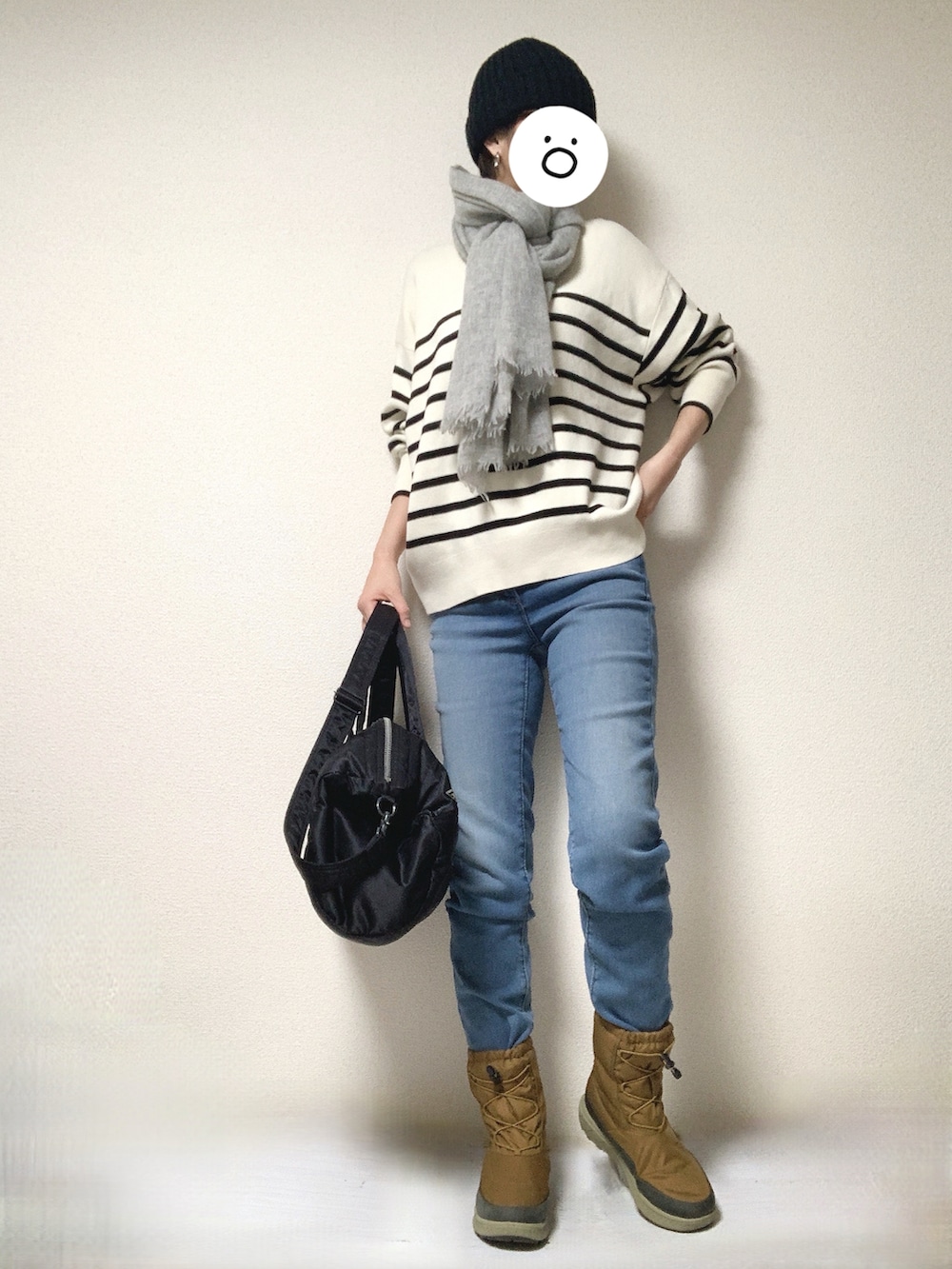 ブラウン系のブーツ、ブルー系のデニムパンツ、ブラック系のボストンバッグを着用したレディースの冬コーディネートの2枚目の写真