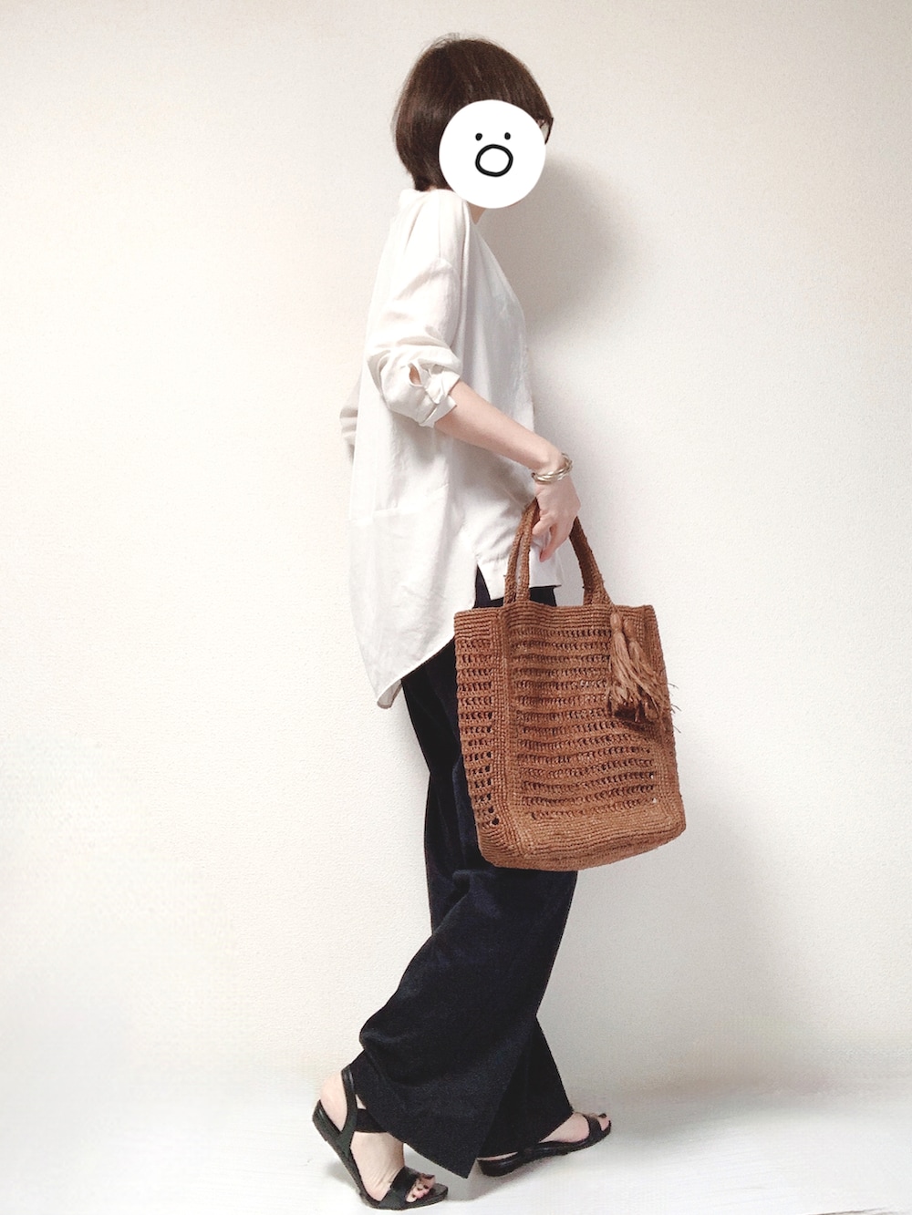 ブラック系のサンダル、ブラック系のチノパンツ、ブラウン系のトートバッグを着用したレディースの秋コーディネートの2枚目の写真