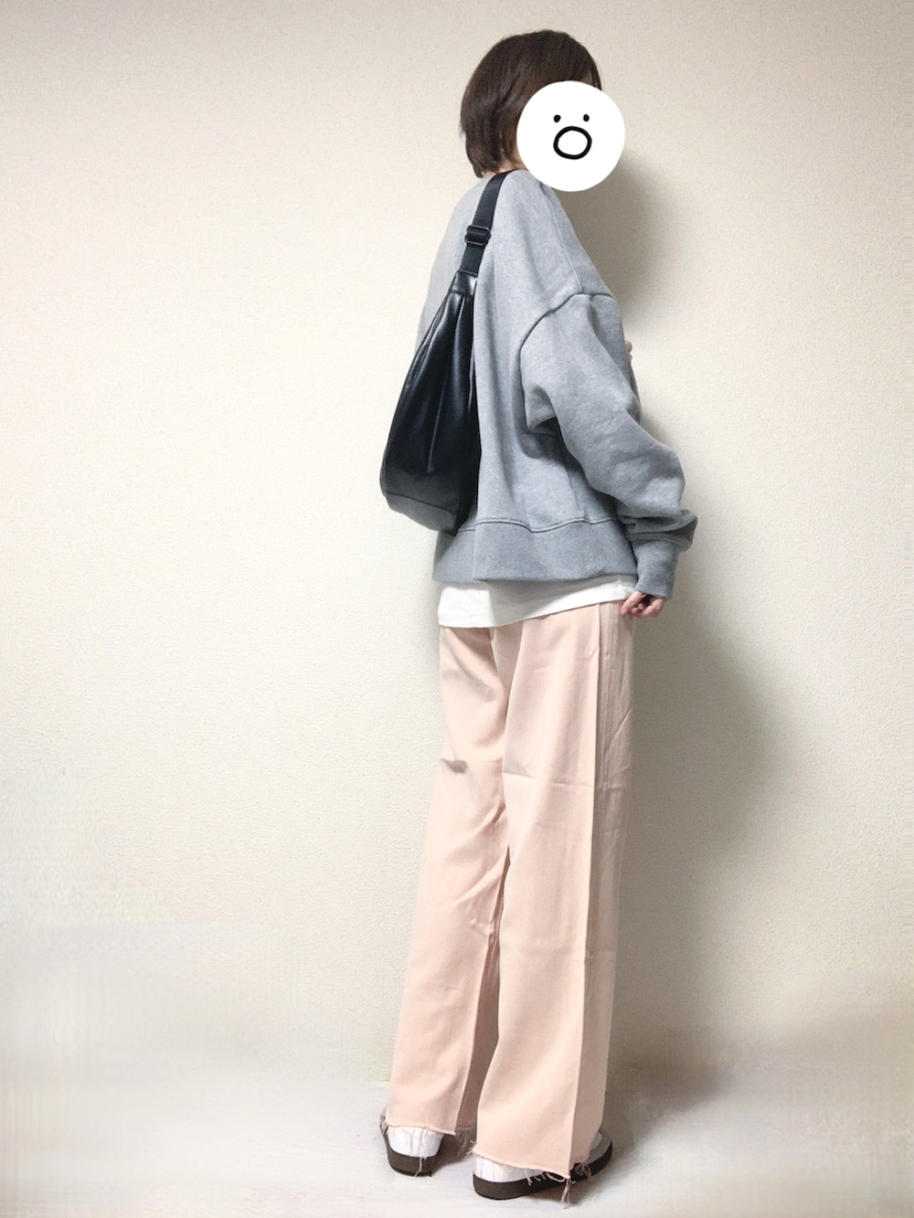 ホワイト系のスニーカー、ピンク系のデニムパンツ、ブラック系のショルダーバッグを着用したレディースの春コーディネートの2枚目の写真