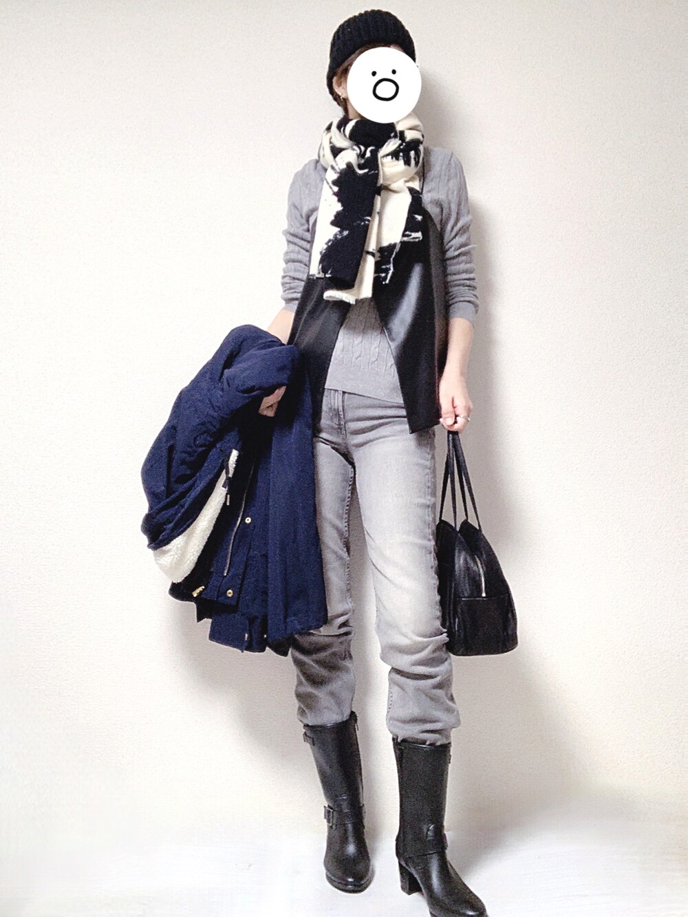 ブラック系のブーツ、ブラック系のトートバッグ、グレー系のデニムパンツを着用したレディースの冬コーディネートの3枚目の写真