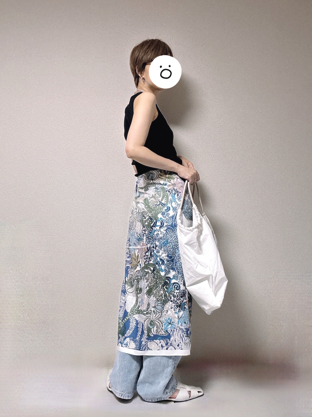 ブルー系のデニムパンツ、ブラック系のタンクトップ、ホワイト系のサンダルを着用したレディースの夏コーディネートの2枚目の写真