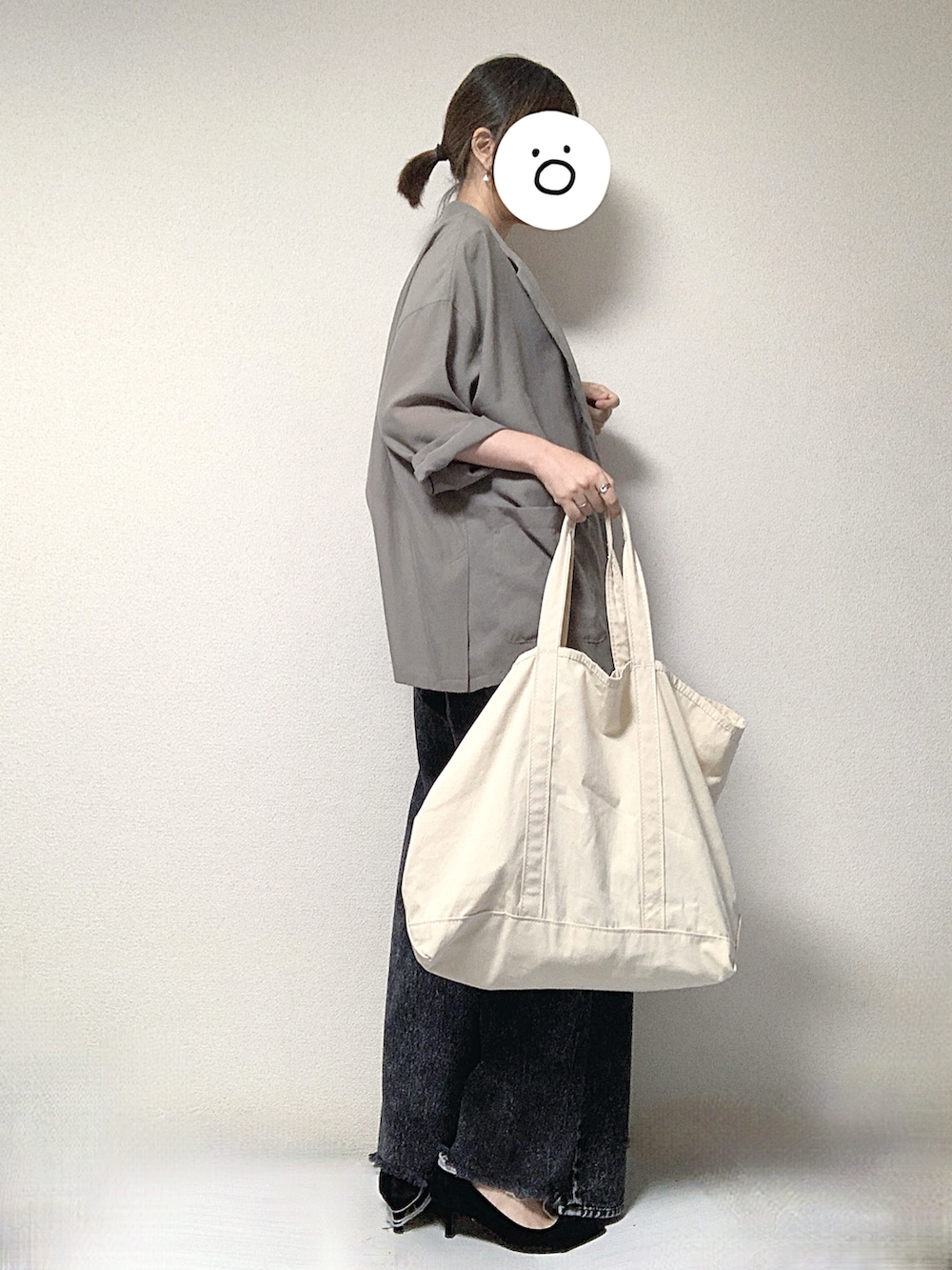 グリーン系のテーラードジャケット、ホワイト系のトートバッグ、ブラック系のパンプスを着用したレディースの夏コーディネートの2枚目の写真