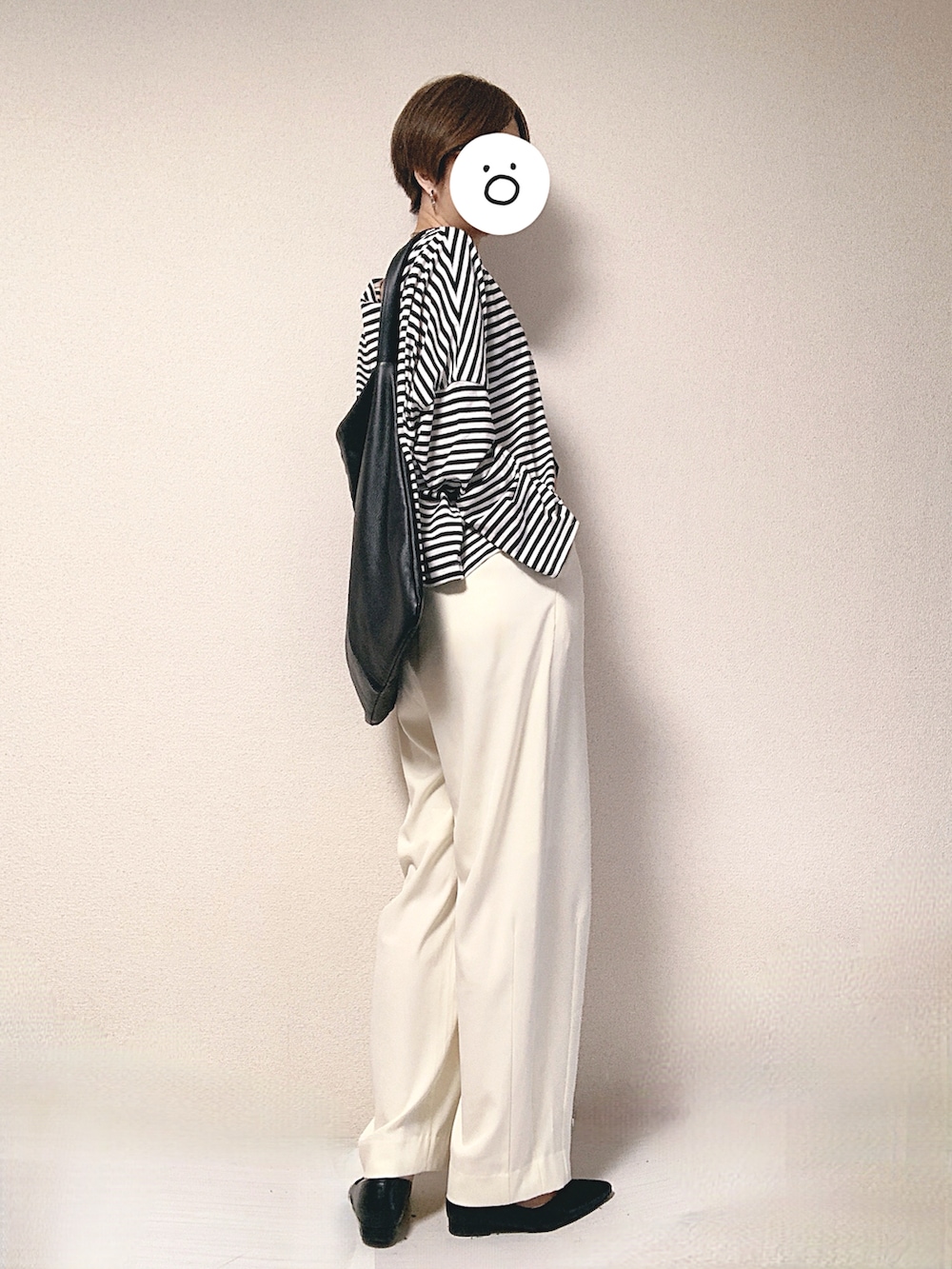 ホワイト系のスラックス、ホワイト系のTシャツ/カットソー、ブラック系のトートバッグを着用したレディースの秋コーディネートの2枚目の写真