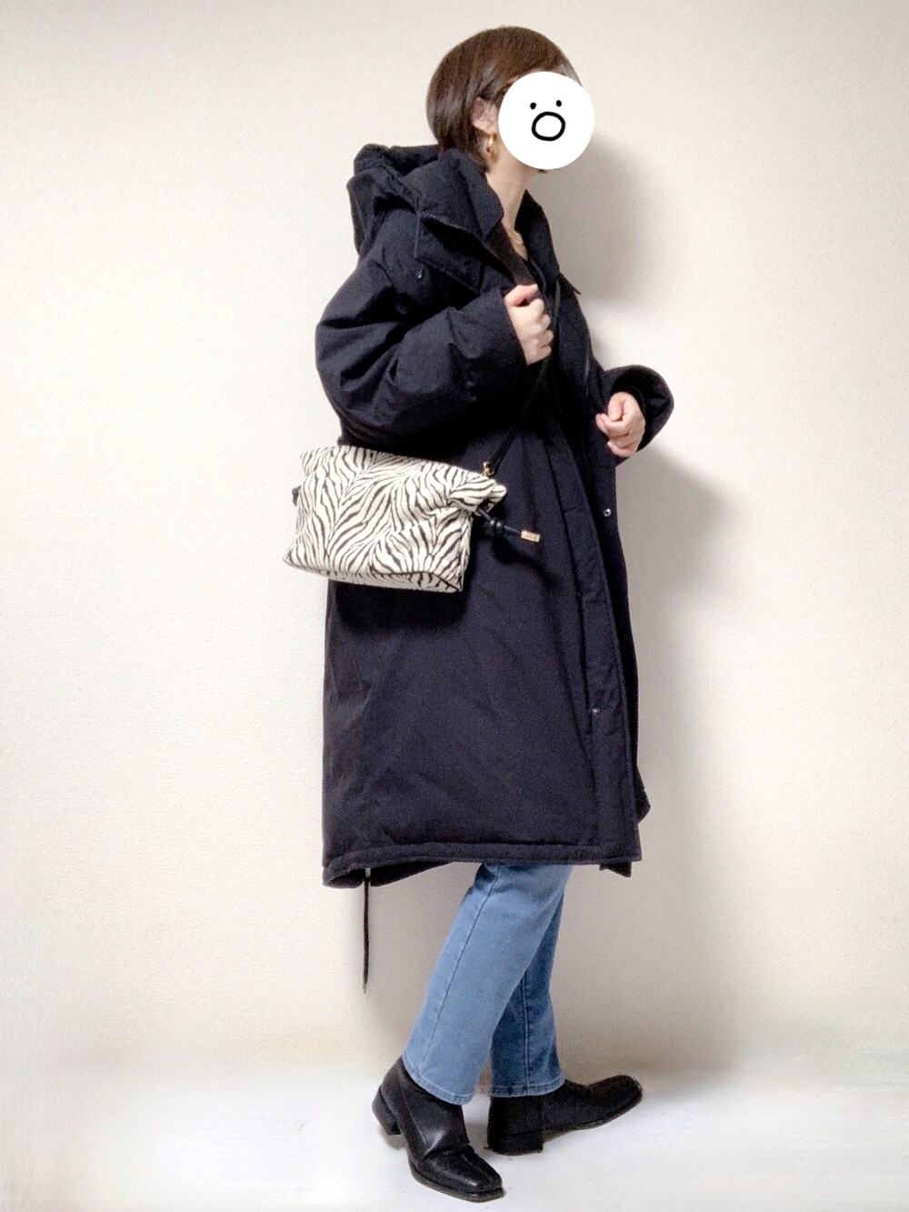 ブラック系のブーツ、ブルー系のデニムパンツ、その他のショルダーバッグを着用したレディースの冬コーディネートの2枚目の写真