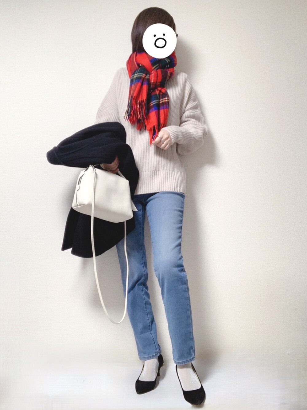 ブラック系のパンプス、ホワイト系のショルダーバッグ、ブルー系のデニムパンツを着用したレディースの冬コーディネートの2枚目の写真