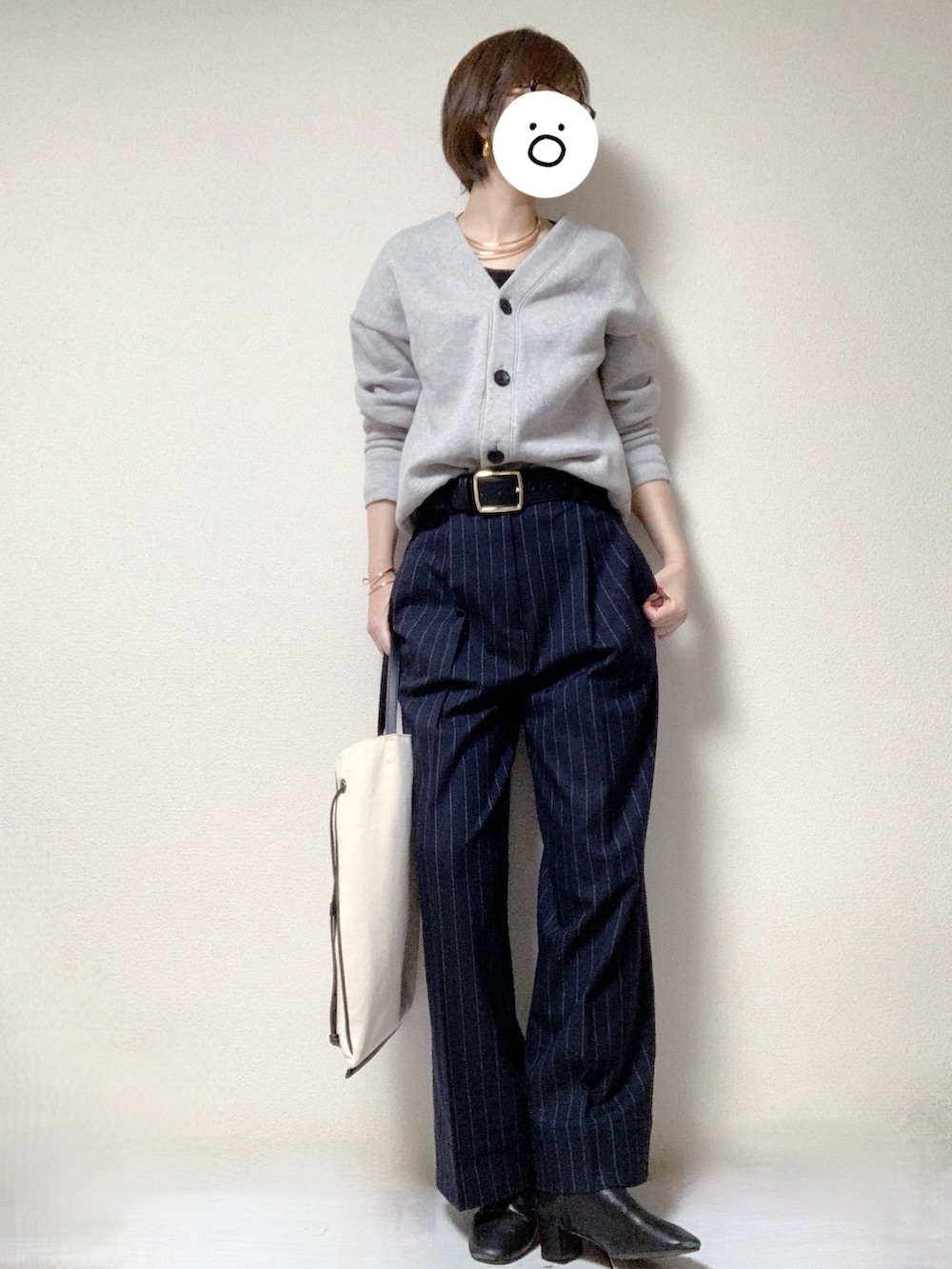 ブラック系のブーツ、ブラック系のトートバッグ、ブルー系のスラックスを着用したレディースの冬コーディネートの2枚目の写真