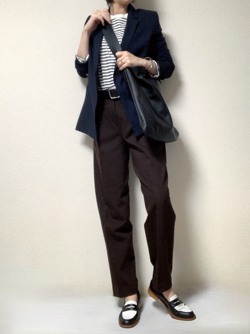 その他のローファー、ブラウン系のスラックス、ブラック系のトートバッグを着用したレディースの冬コーディネートの2枚目の写真