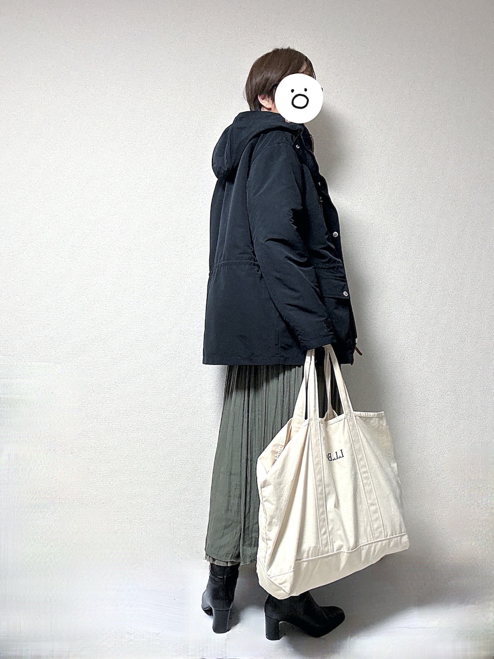 ブラック系のマウンテンパーカー、ブラック系のスウェット、ベージュ系のスカートを着用したレディースの冬コーディネートの2枚目の写真