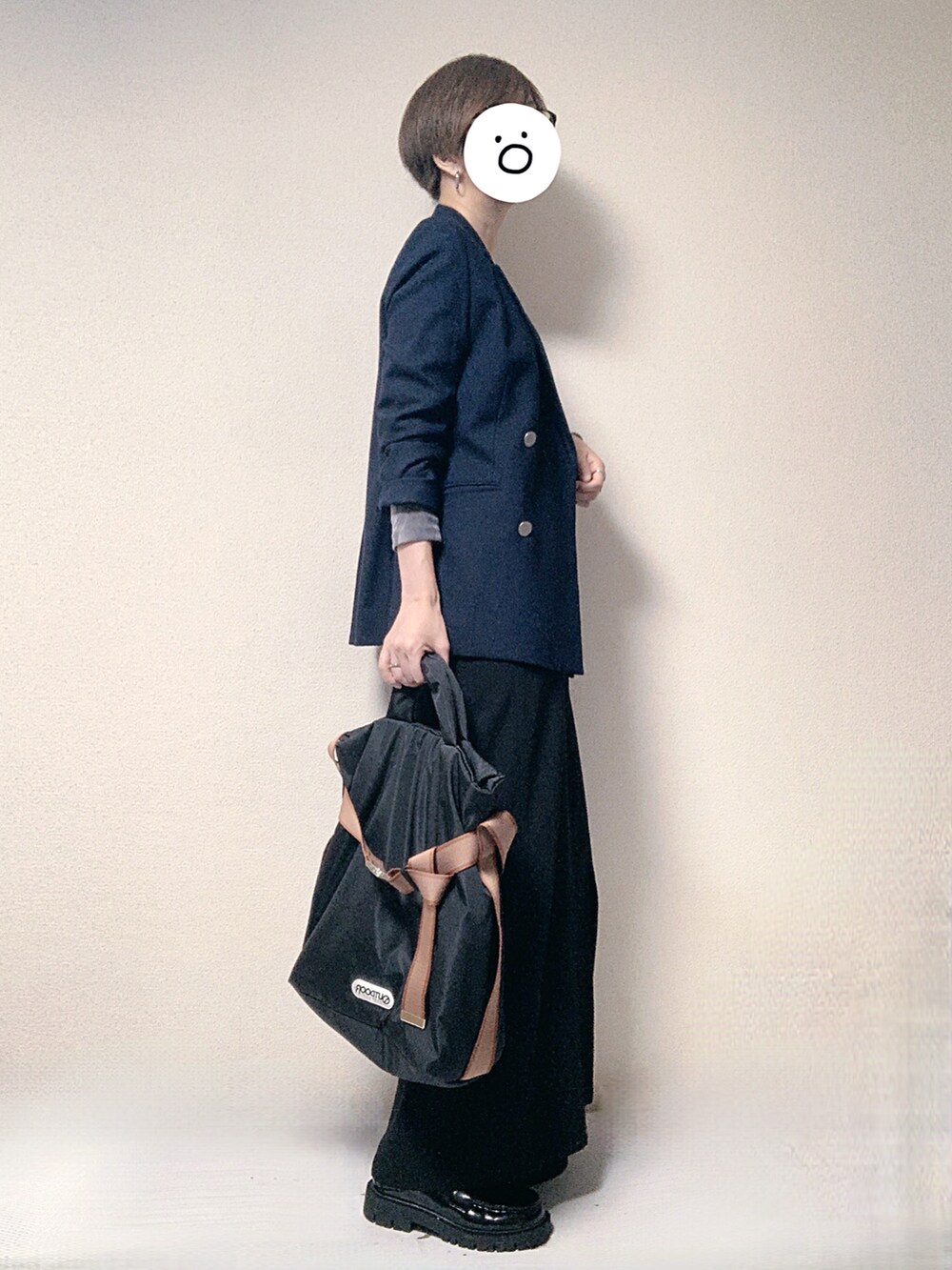 ブルー系のテーラードジャケット、ブラック系のワンピース、ブラック系のトートバッグを着用したレディースの秋コーディネートの2枚目の写真