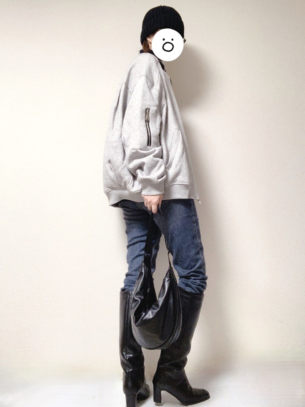 ブルー系のデニムパンツ、ブラック系のブーツ、ブラック系のショルダーバッグを着用したレディースの冬コーディネートの2枚目の写真