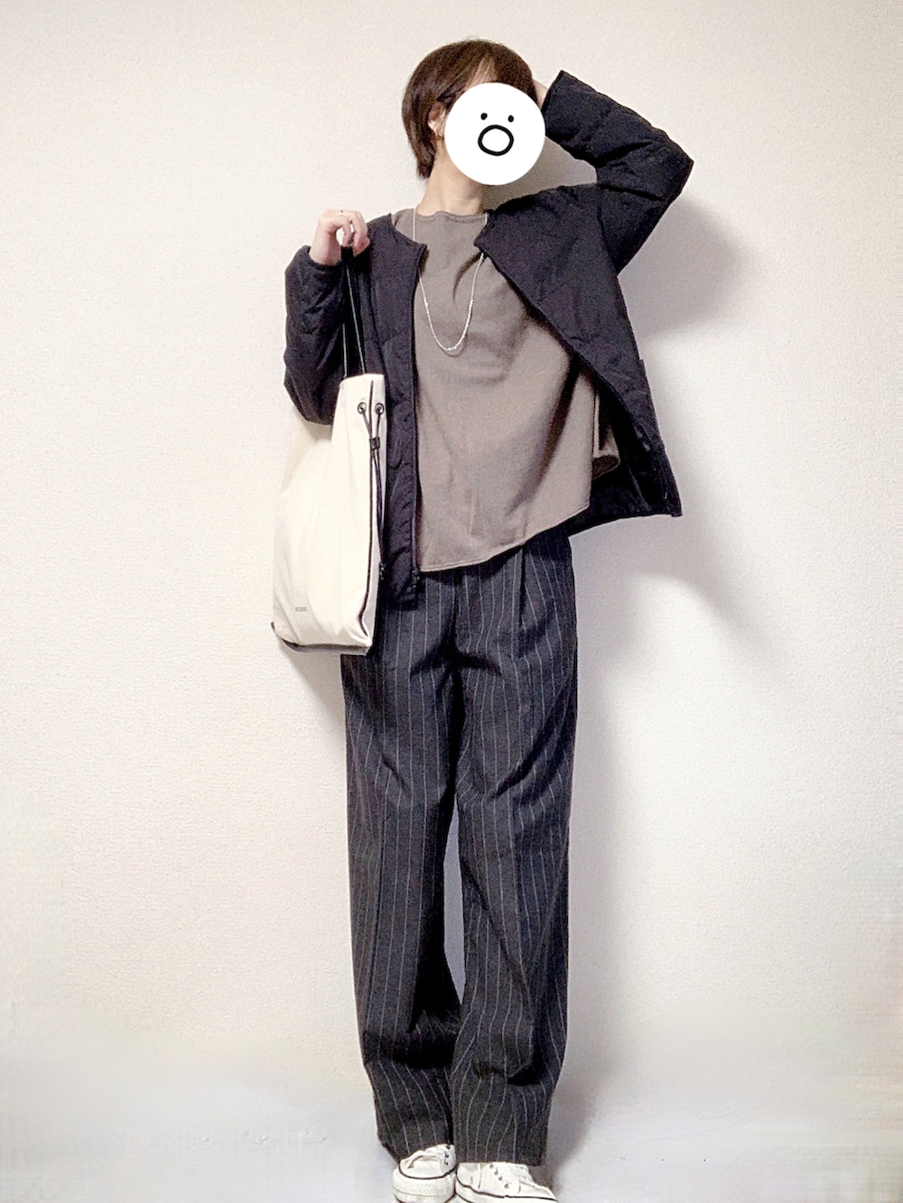 ホワイト系のスニーカー、グレー系のスラックス、ブラック系のトートバッグを着用したレディースの秋コーディネートの3枚目の写真