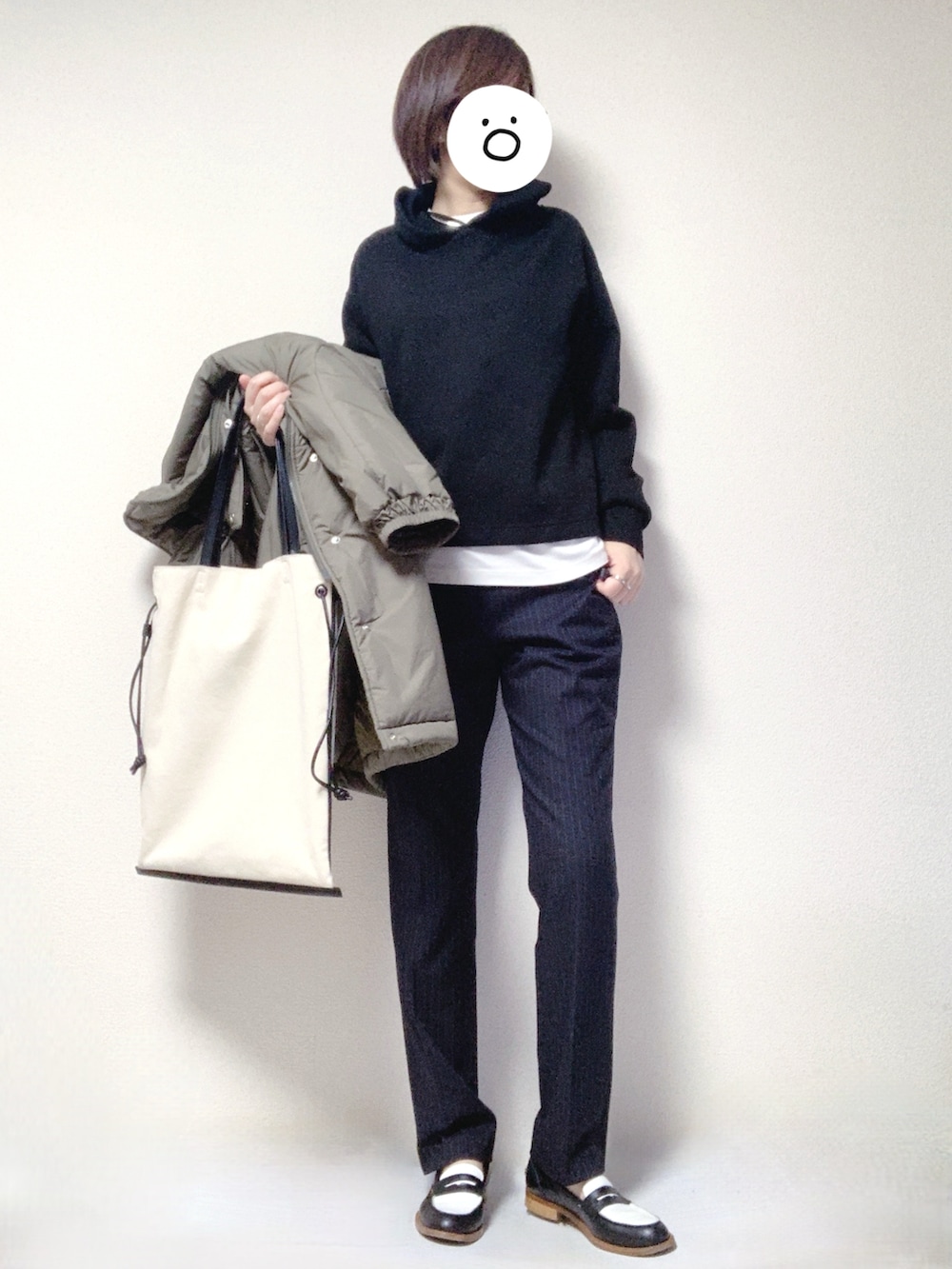 その他のローファー、ブラック系のトートバッグ、ブルー系のスラックスを着用したレディースの冬コーディネートの2枚目の写真