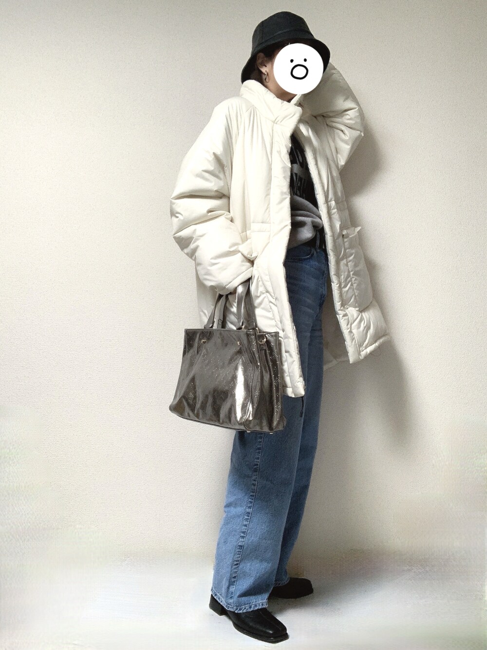 ブラック系のブーツ、ブルー系のデニムパンツ、ホワイト系のその他アウターを着用したレディースの冬コーディネートの2枚目の写真