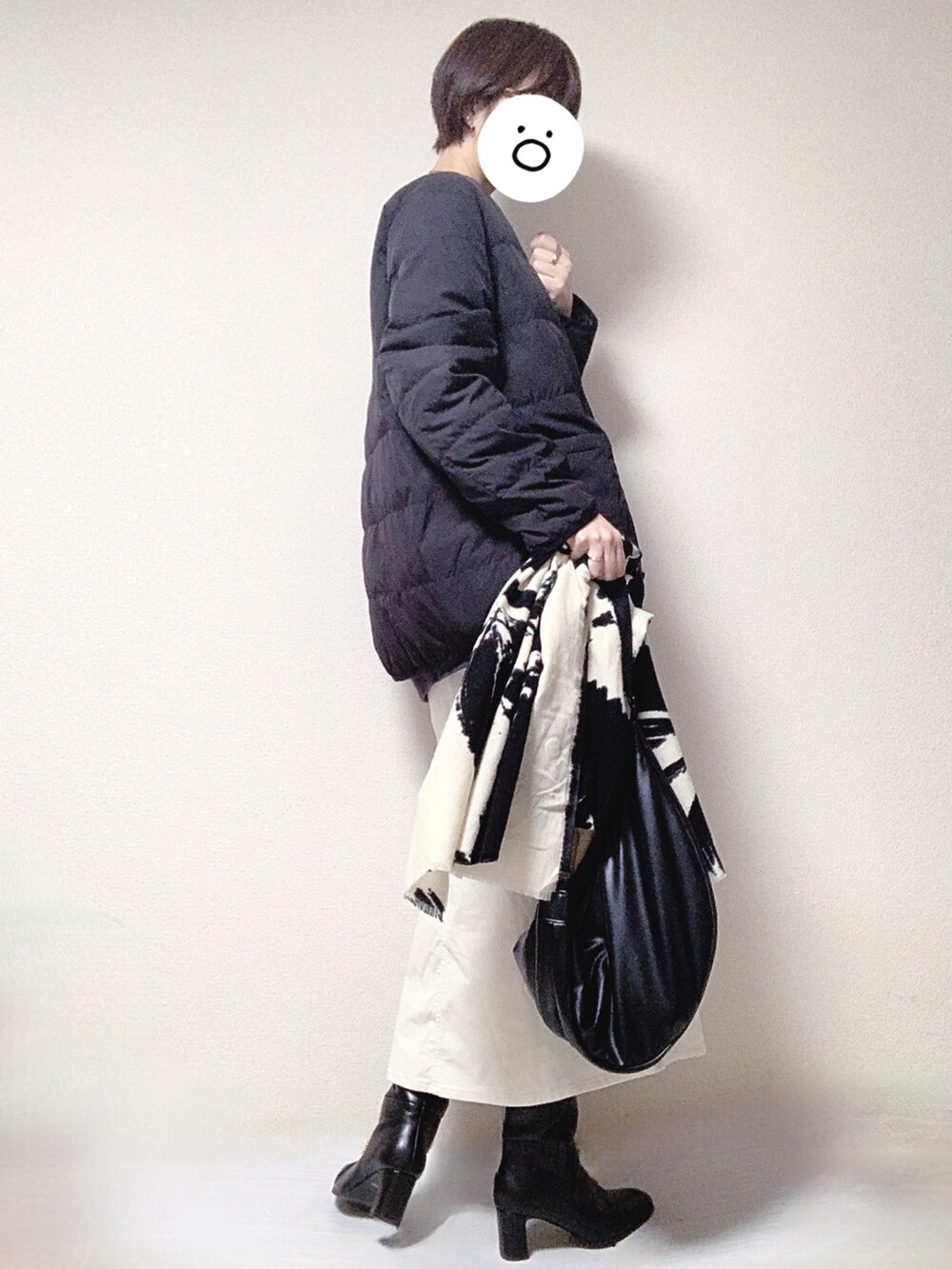 ブラック系のブーツ、ホワイト系のスカート、ブラック系のショルダーバッグを着用したレディースの秋コーディネートの3枚目の写真