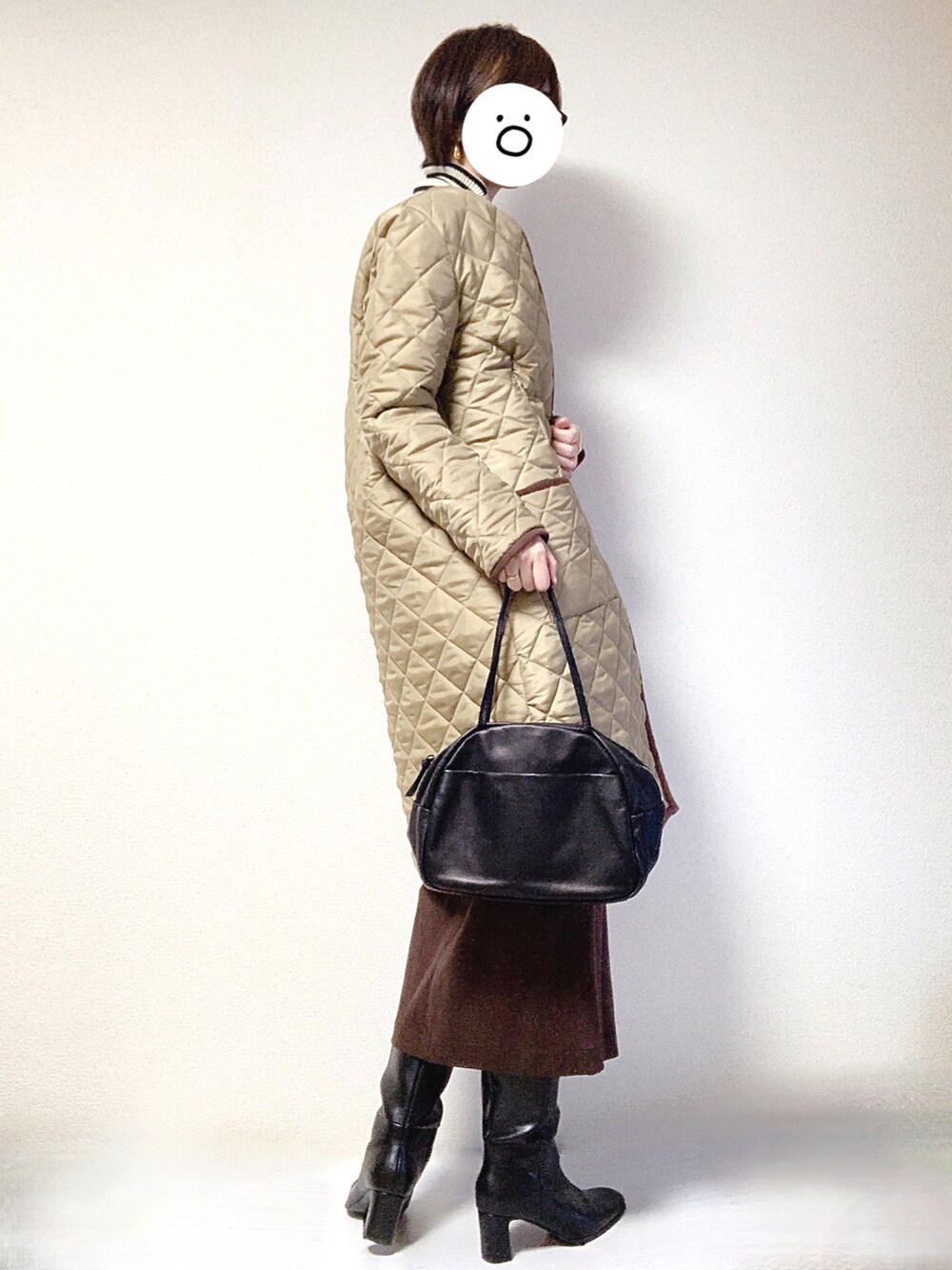 ブラック系のブーツ、ブラック系のトートバッグ、ベージュ系のその他アウターを着用したレディースの冬コーディネートの3枚目の写真