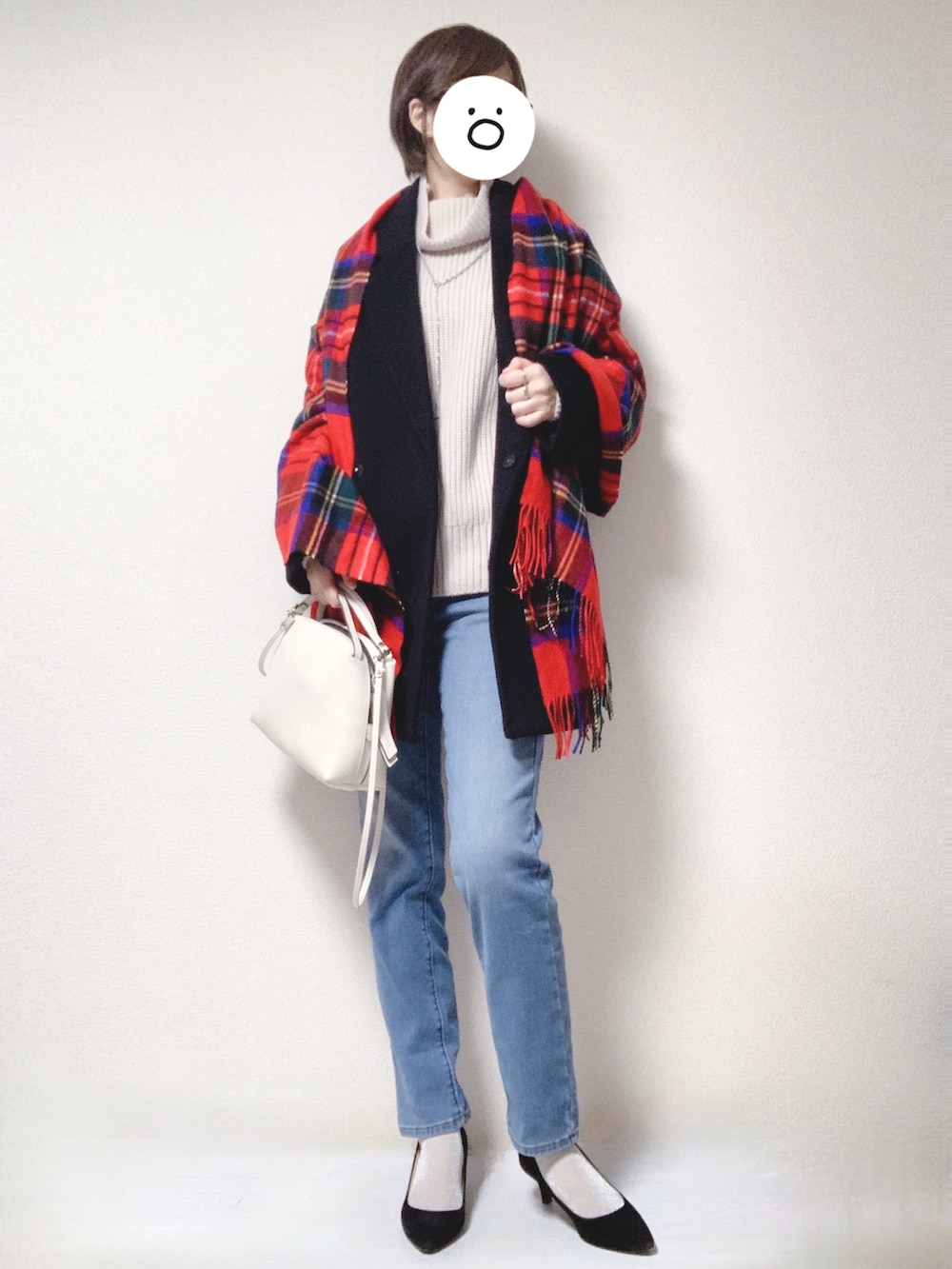 ブラック系のパンプス、ホワイト系のショルダーバッグ、ブルー系のデニムパンツを着用したレディースの冬コーディネートの3枚目の写真